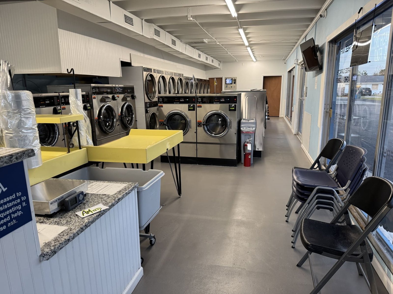 Original Ridgewood laundromat interior with Dexter machines, folding tables, carts and seating